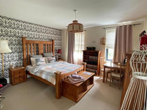 a bedroom with a bed and a table and a desk at Upton Country Park Guest House in Northampton