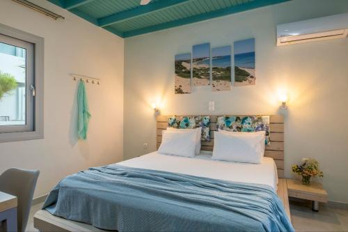 a bedroom with a large bed with blue sheets and pillows at Paradisos in Frangokastello