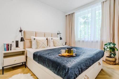 a bedroom with a bed with a tray of fruit on it at Lumina lux apart with a balcony near Palace of Culture and Science in Warsaw