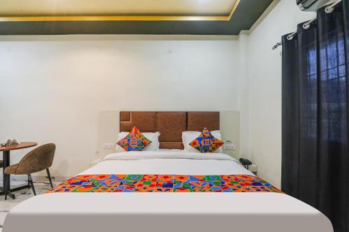 een slaapkamer met een groot bed en een tafel bij FabHotel Saalt Bandhan Resort in Muzaffarpur