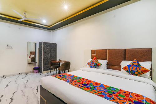 1 dormitorio con 1 cama grande y escritorio en FabHotel Saalt Bandhan Resort en Muzaffarpur