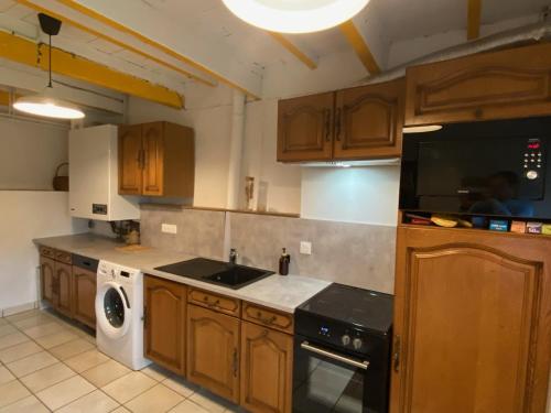 une cuisine avec un évier et une cuisinière four supérieur dans l'établissement Au coeur des volcans, à Ceyssat