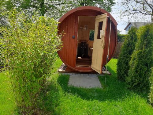 een kleine houten hut in het gras in een tuin bij Ferienhaus Deine Zeit mit SAUNA und WALLBOX in Nettersheim