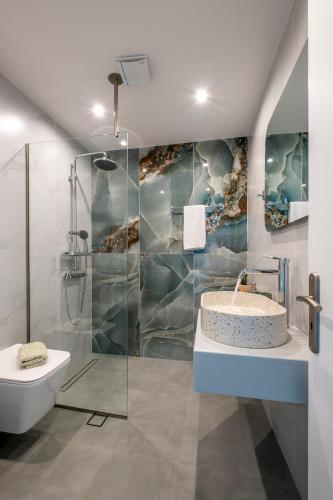 a bathroom with a shower and a sink and a toilet at Paradisos in Frangokastello