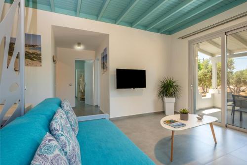 a living room with a blue couch and a table at Paradisos in Frangokastello