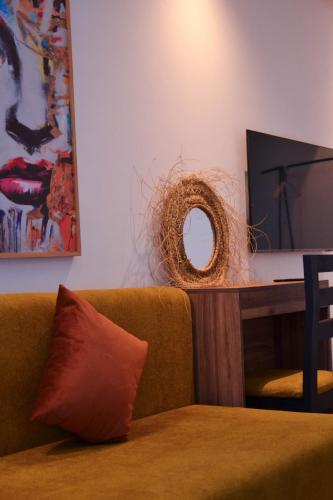 a couch with a mirror next to a table at Playa Del Sol Surf House in Tamraght Ouzdar