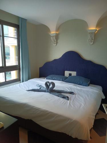 a bedroom with a large bed with a blue headboard at Espana Condo Resort By K&T in Jomtien Beach