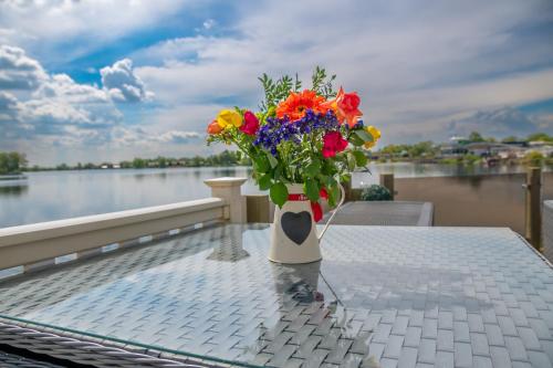 a vase filled with flowers sitting on a table at Lake View with Private Hot Tub at Tattershall Lakes in Tattershall
