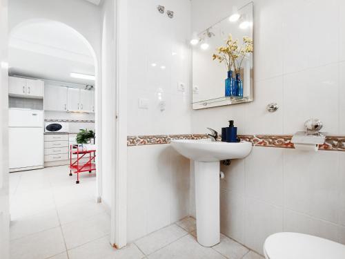 a white bathroom with a sink and a mirror at Sunny Blue Home - near Pools, Beach and Golf in Los Alcázares