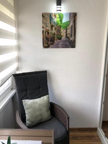 a chair in a corner with a picture on the wall at Welcome to the Apartment Mesic- Airport Sarajevo in Sarajevo