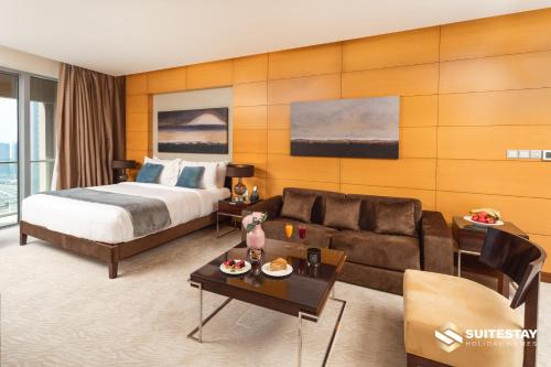 ドバイにあるOSTAY -Address Dubai Mall - The Residenceのベッドとソファ付きのホテルルーム