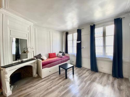 - un salon avec un canapé rouge et une cheminée dans l'établissement Charmant studio plein centre historique - 071, à Rouen