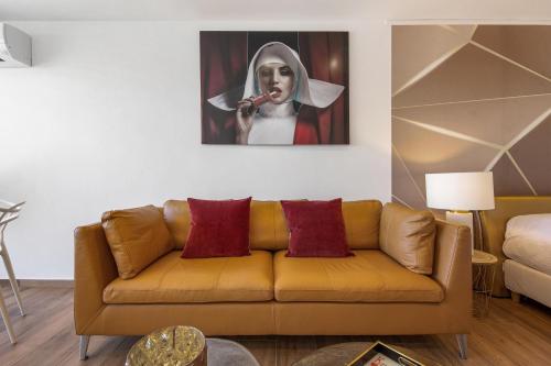 - un salon avec un canapé et une peinture d'une femme jouant du violon dans l'établissement Village Naturiste R4N - Le White&Sea Héliopolis, au Cap d'Agde