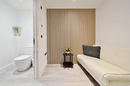 ein Badezimmer mit einem WC und einem Sofa darin in der Unterkunft Acorn House in Dorchester