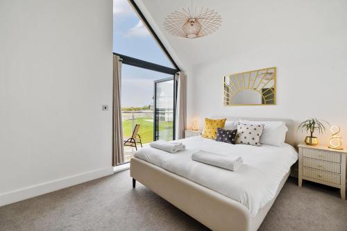 ein weißes Schlafzimmer mit einem Bett und einem großen Fenster in der Unterkunft Acorn House in Dorchester