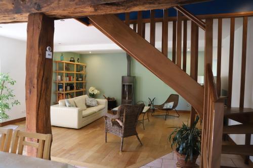 a living room with a staircase and a couch at La Grange du Tôt in Fontenay