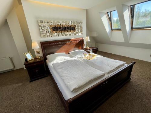 een slaapkamer met een groot bed met witte lakens bij Mezonet Tatry in Štôla