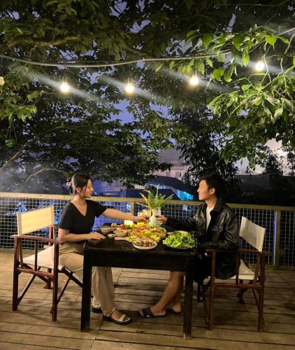 two women and a man sitting at a table with food at Love House Homestay SAPA in Sa Pa