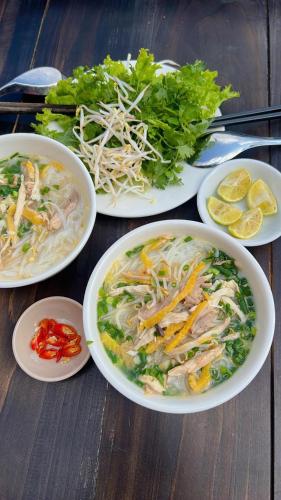 four plates of food on a wooden table at Love House Homestay SAPA in Sa Pa