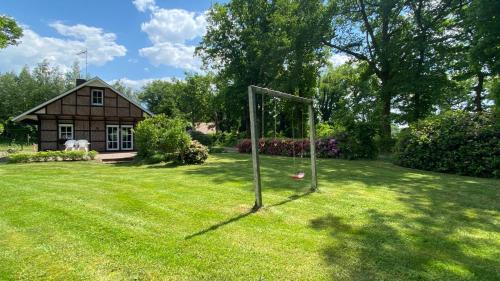 a yard with a goal in the grass with a house at Hexenhäuschen im Ammerland in Apen