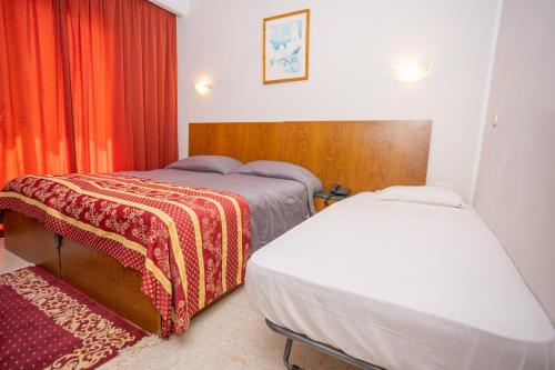 um quarto de hotel com duas camas e uma janela em Hôtel le passage em Tunes