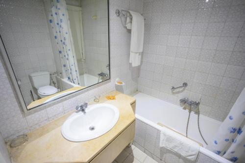 uma casa de banho com um lavatório, uma banheira e um WC. em Hôtel le passage em Tunes