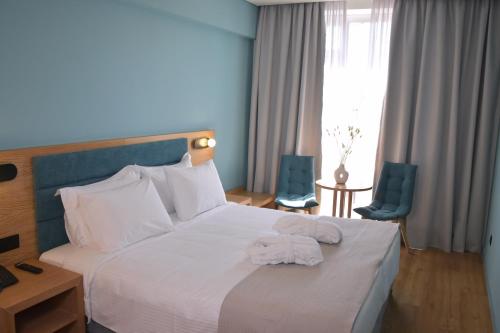 Una habitación de hotel con una cama con dos toallas. en Arethusa Hotel, en Atenas