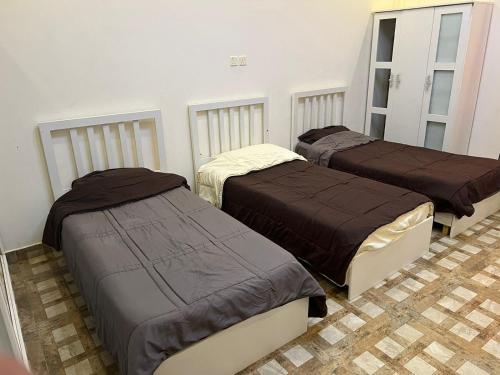 um quarto com três camas num quarto em سرايا الياسمين em Ilbaras