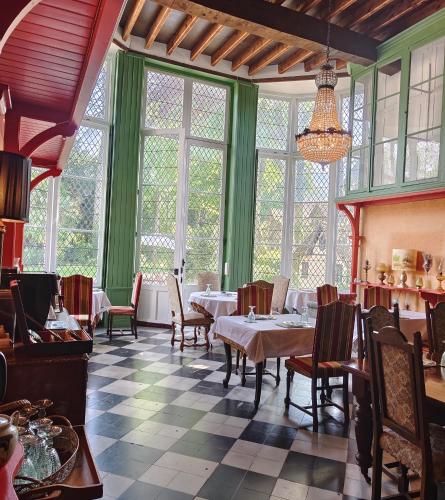 une salle à manger avec tables, chaises et fenêtres dans l'établissement Chateau de la Grand'Maison, à Bellême