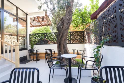 a patio with chairs and a table and a tree at Audo Local in Antalya