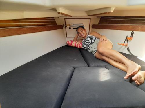 a young man laying on a bunk bed in a tiny house at Sailboat Nika, Tilly's Sail Tours in Siaton