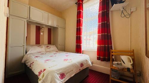 a small bedroom with a bed and a window at Delamere Hotel in Blackpool