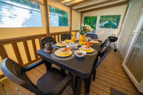 a table with plates of food on a balcony at La Belle au Bois Normand in Litteau