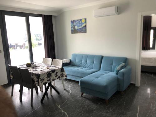 Sofya Suites في فتحية: غرفة معيشة مع أريكة زرقاء وطاولة
