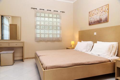 a bedroom with a large bed and a window at ELPIS appartment in Vitalades