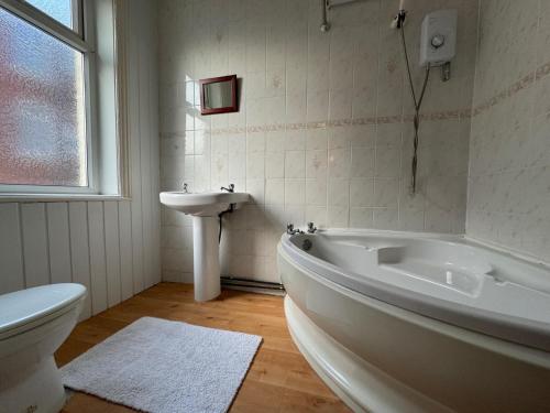a bathroom with a tub and a sink and a toilet at Delamere Hotel in Blackpool