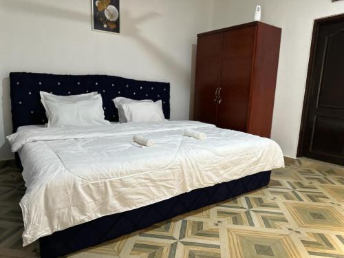 Tokuse的住宿－Nyawoyi Villa，一间卧室配有一张带白色床单的大床