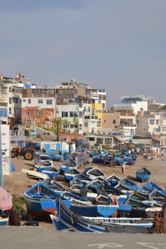 a bunch of boats are lined up on the beach at Playa Del Sol Surf House in Tamraght Ouzdar