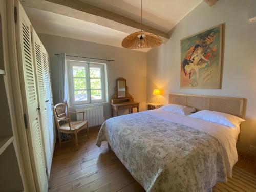 een slaapkamer met een groot bed en een stoel bij La Paradoune 2 in Paradou