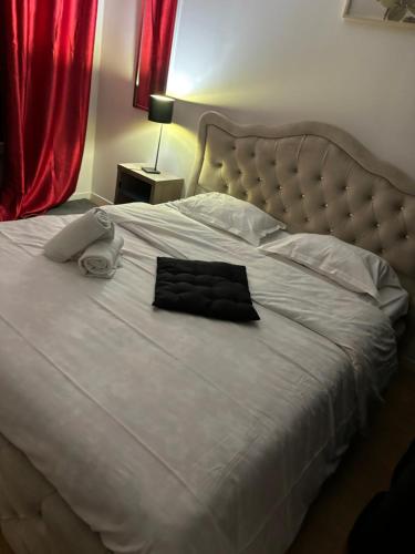 un grand lit blanc avec une robe noire dessus dans l'établissement Agréable Appartementbuttes-Chaumont, à Paris