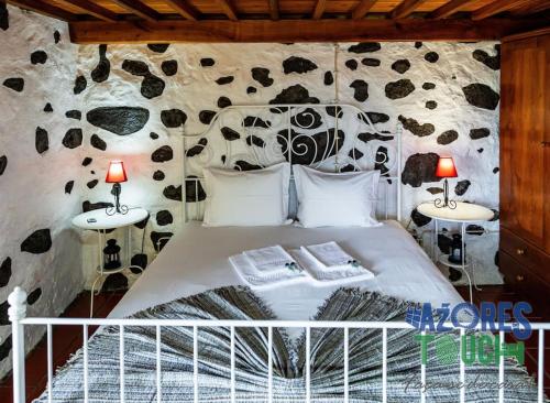 1 dormitorio con 1 cama con 2 lámparas en las mesas en O Pomar do Gasparinho, en Santa Cruz da Graciosa