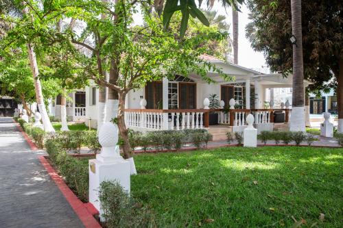 a white house with a tree in the yard at Coconut Residence & Spa in Kololi