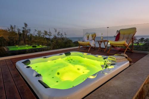 a green bath tub sitting on top of a deck at Blue Pearl Villa in AmigdhalokeFálion