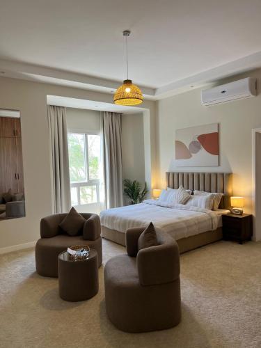 a large bedroom with a bed and two chairs at Halima Shared Housing - Female only in Dubai