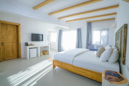 Kassandra Boutique Hotel في أولدينيس: غرفة نوم بيضاء بسرير كبير وتلفزيون