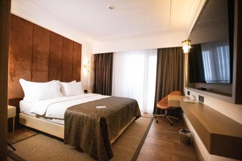 a hotel room with a bed and a flat screen tv at La Quinta by Wyndham Giresun in Giresun