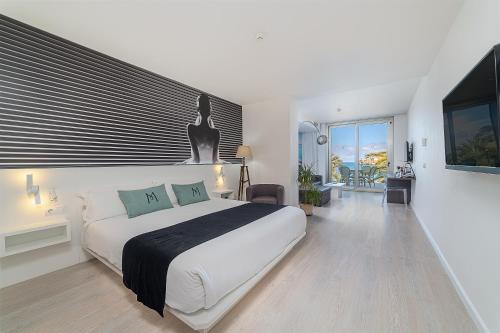 ein Schlafzimmer mit einem großen weißen Bett und einem Balkon in der Unterkunft Hotel Boutique Minister 4Sup in Port de Sóller