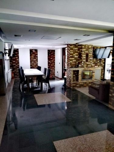 a dining room with a table and a fireplace at Villa Golful Verde in Colibiţa