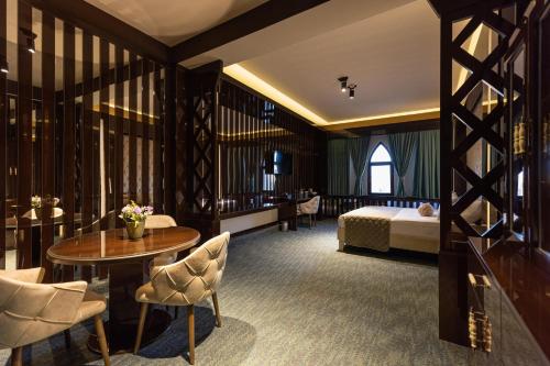 una camera d'albergo con letto, tavolo e sedie di Dashli Qala Hotel a Ganja