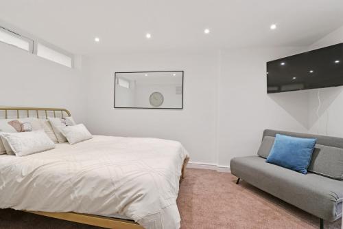 biała sypialnia z łóżkiem i kanapą w obiekcie Finsbury Park Studios w Londynie